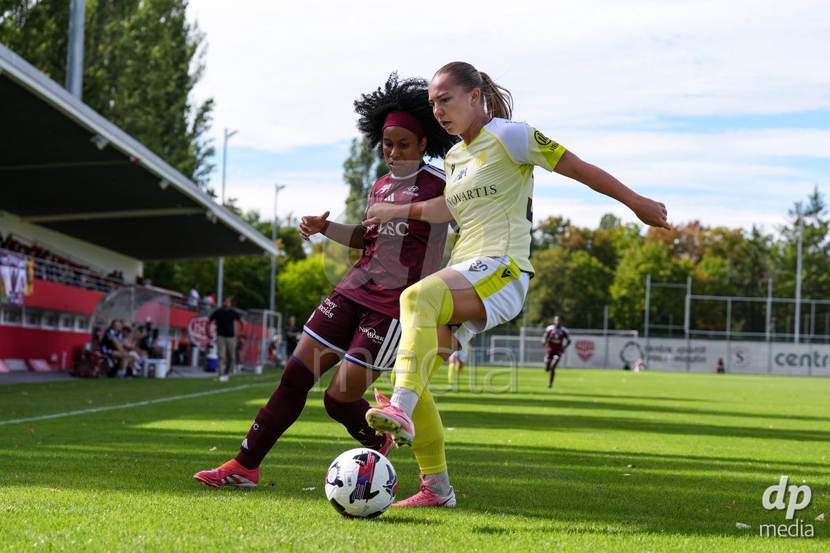 Geneva, Switzerland - August 29: Mickaella Francoise Halooa Cardia of Servette (L) and Krystyna Flis of FC Basel (R) battle for the ball (duel) during the AXA Women's Super League match between Servette FC Chenois Feminin and FC Basel 1893 at Stade de Trois-Chene on August 29, 2026 in Geneva, Switzerland.
