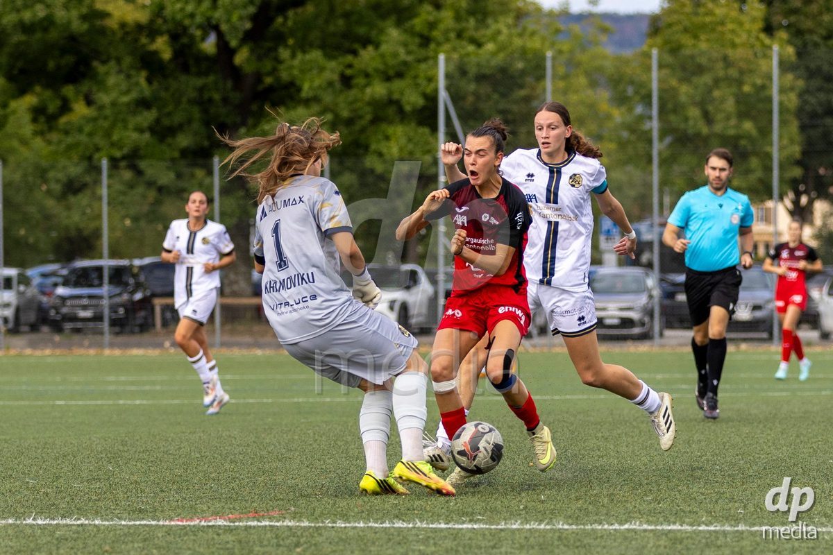 Aarau, Switzerland - September 5: Giulia Bison of FC Aarau Frauen (C) fights for the ball with goalkeeper Lea Kramowiku of FC Luzern Frauen (L) during the AXA Women's Super League match between FC Aarau Frauen and FC Luzern at Sportanlage Schachen on September 5, 2026 in Aarau, Switzerland.