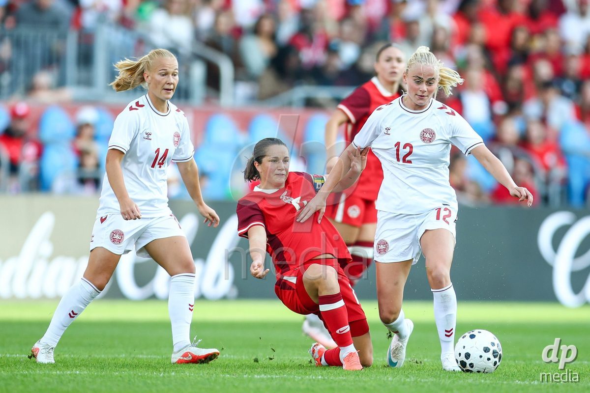 TORONTO, CANADA - OCTOBER 12: Sofie Bredgaard of Denmark (L) and Kathrine Kühl of Denmark (R) battle against Jessie Fleming of Canada (C) during the International Friendly match between Canada and Denmark at BMO Field on October 12, 2026 in Toronto, Canada.