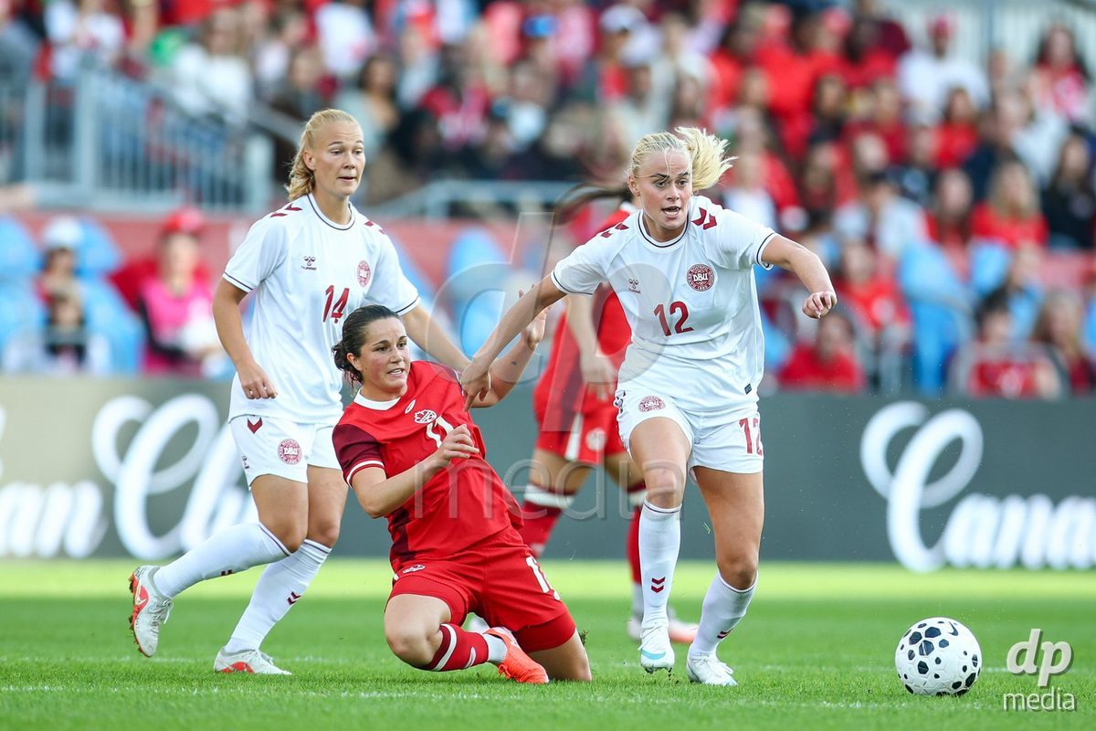 TORONTO, CANADA - OCTOBER 12: Sofie Bredgaard of Denmark (L) and Kathrine Kühl of Denmark (R) battle against Jessie Fleming of Canada (C) during the International Friendly match between Canada and Denmark at BMO Field on October 12, 2026 in Toronto, Canada.