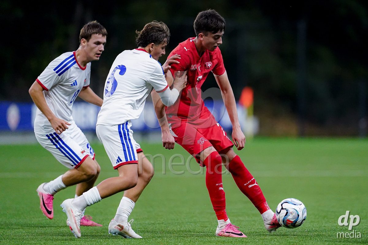 SCHAAN, LIECHTENSTEIN - OCTOBER 15: Amri Dzaferi of Switzerland and Florian Jahiu of Liechtenstein battle for the ball during the UEFA European Under-17 Qualifier match between Switzerland and Liechtenstein at LFV Campus Rheinwiese on October 15, 2026 in Schaan, Liechtenstein.