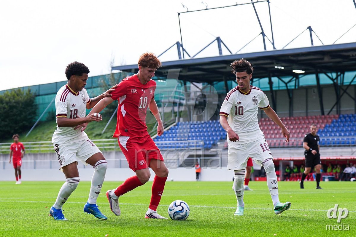 VADUZ, LIECHTENSTEIN - OCTOBER 18: Eron Kele of Switzerland /C) battles for the ball (duel) against Darek Barriento of Spain (L) and Aitor Torondel of Spain (R) during the UEFA European Under-17 Qualifier match between Switzerland and Spain at Rheinpark Stadion on October 18, 2026 in Vaduz, Liechtenstein.